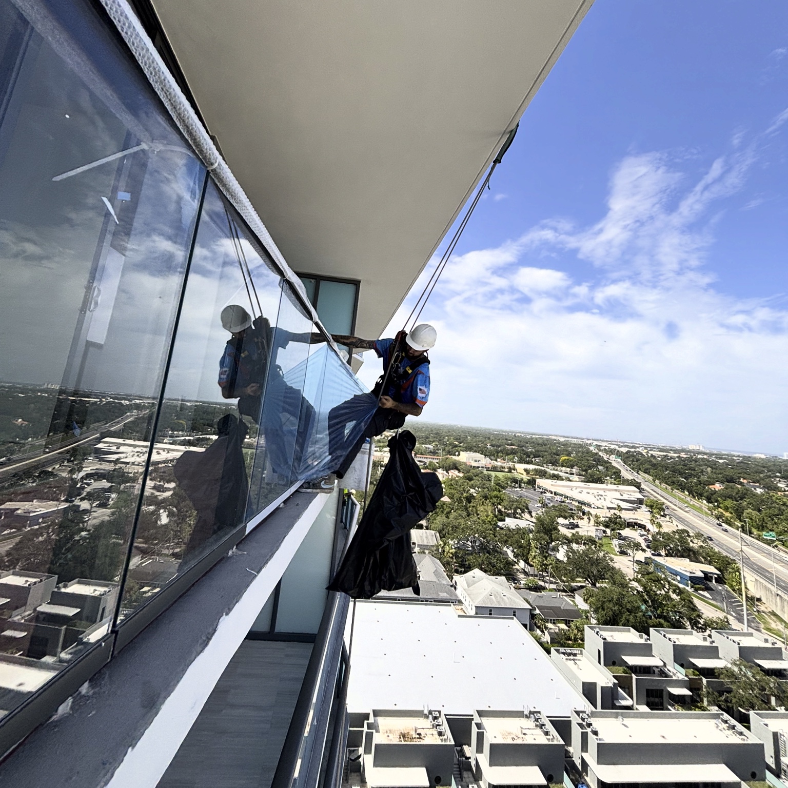 Rope access window cleaning on a high-rise balcony